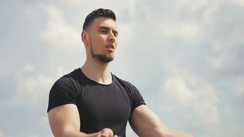 Handsome, young man with a beard in a black T-shirt demonstrates mastery with 스톡 동영상 119475454