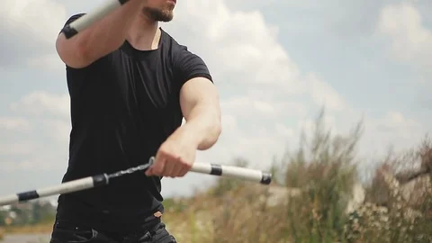 Handsome, young man with a beard in a black T-shirt demonstrates mastery with Stock Footage 119475474