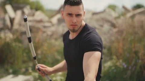 Handsome, young man with a beard in a black T-shirt, looks into the camera and 库存影片 119475488