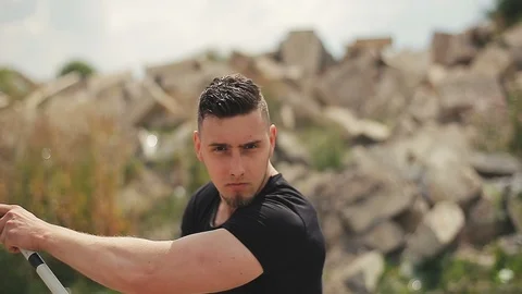 Handsome, young man with a beard in a black T-shirt, looks into the camera and Stock Footage 119475494