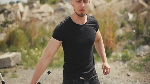 Handsome, young man with a beard in a black T-shirt, looks into the camera and 스톡 동영상 119475555