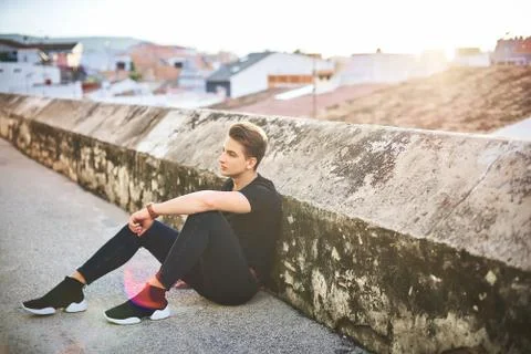 Handsome young man in black posing on the street Stock Photos