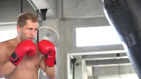 Handsome young man boxer exercising with a punching bag at training fitness g Stock Footage 162806739