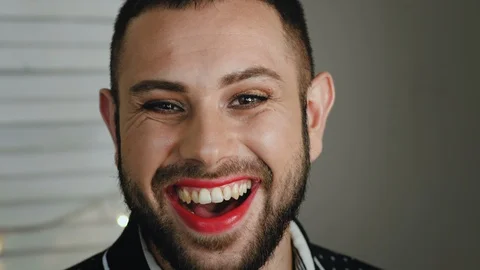 Handsome young man with bright makeup laughing at the camera Stock Footage 110974417