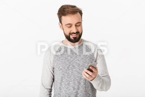 Handsome young man chatting by mobile phone looking aside. Stock Photos