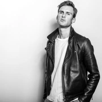 Handsome young man in classic leather jacket. Black-white studio portrait. Foto stock