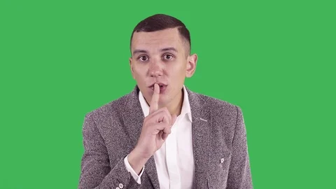 Handsome young man doing Hush sign with finger on lips, looking at camera. Stock Footage 85855789