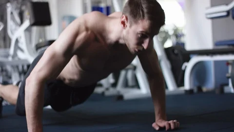 Handsome young man doing push ups in a gym Stock-Footage 105945701