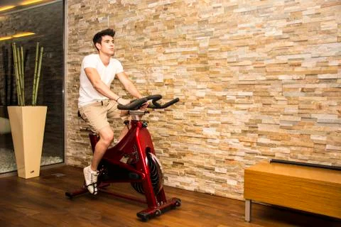 Handsome young man doing spinning on bike Stock Photos