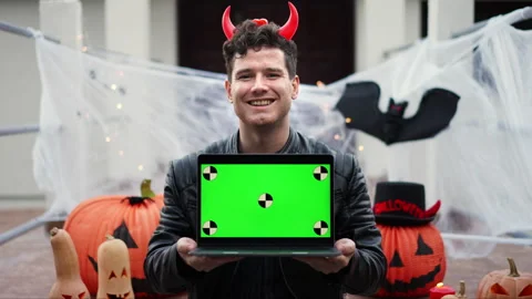 Handsome Young man dressed as a vampire devil with makeup holds a pumpkin Jack O Stock Footage 264123851