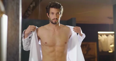 A handsome young man is dressing a white shirt for going to work in his bedroom. Stock Footage 114717918