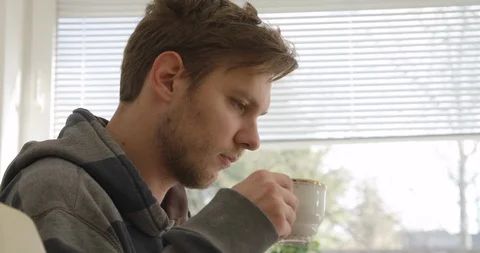 Handsome young man drinking coffee in his home, close up shot. Stock Footage 124103029