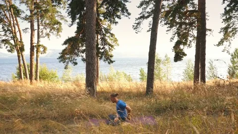 Handsome Young Man During Meditation or Doing an Outdoor Yoga Exercise in the Stock Footage 80793965