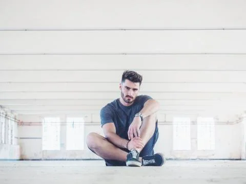 Handsome young man in empty warehouse Stock Photos