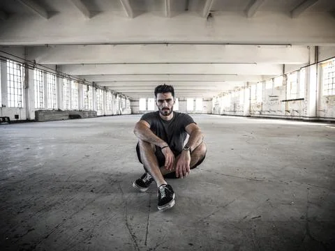 Handsome young man in empty warehouse Stock Photos