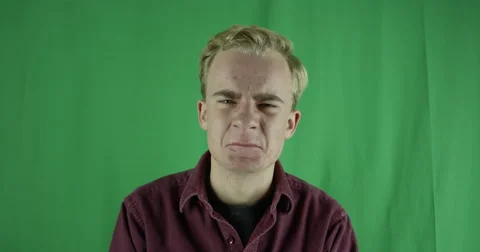 Handsome young man flips off camera on a greenscreen Vidéo 59724016