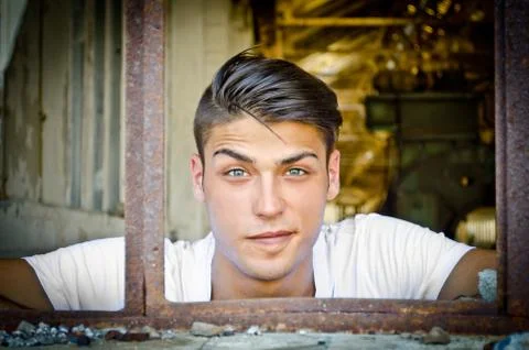 Handsome young man with funny expression in rusty window Stock Photos