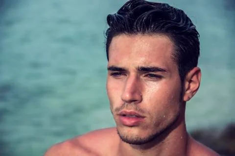 Handsome young man getting out of water with wet hair Stock Photos