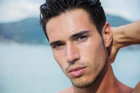 Handsome young man getting out of water with wet hair Stock Photos