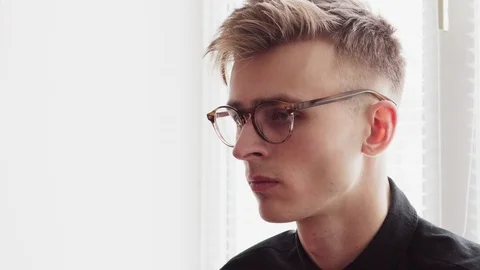Handsome young man in glasses looking away and turns head Stock Footage 86209500