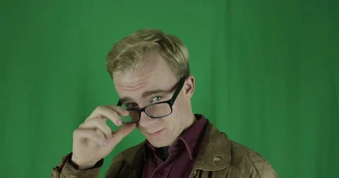 Handsome young man with glasses poses in front of a greenscreen Vidéo 59721842