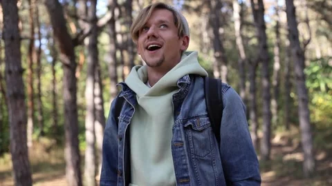 Handsome young man hiking in forest taking protection mask off breathing deeply. Stock Footage 241574213