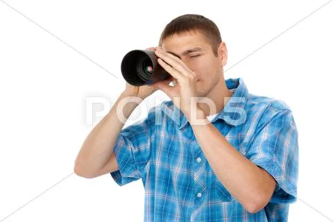 Handsome young man holding camera lens like it was spyglass on white backgrou Stock Photos
