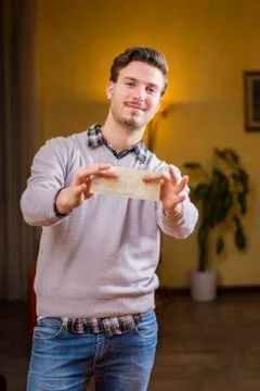 Handsome young man holding check in his hands Stock Photos