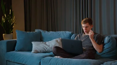 Handsome young man in home clothes working at his computer from home Stock Footage 241084301