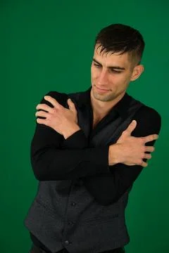 Handsome young man hugging himself on blue background Stock Photos