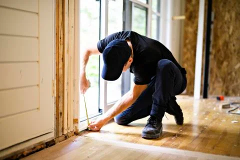 A handsome young man installing Double Sliding Patio Door in a new house Stock-Fotos