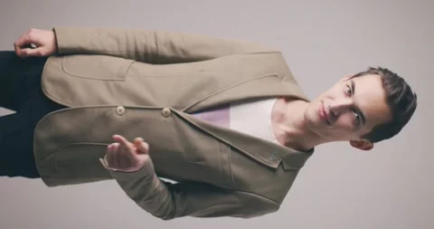 Handsome young man in a jacket isolated over grey wall background showing call Stock Footage 147998382