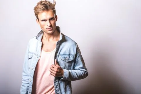 Handsome young man in jeans jacket pose in studio. Stock Photos