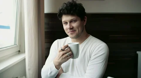 Handsome young man on kitchen with cup in hands. 動画素材 47829576