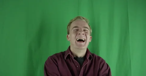 Handsome young man laughs really hard on a greenscreen Stock Footage 59725042