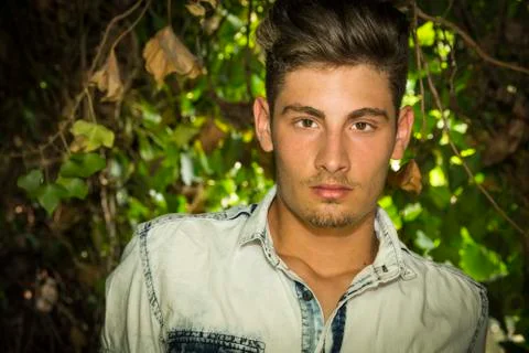 Handsome young man looking among plants and bushes Stock Photos