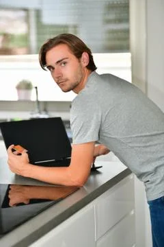 Handsome young man looking back at the camera while holding a credit card and Stock Photos