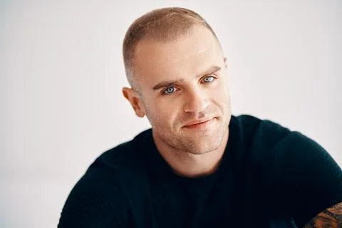 Handsome young man looking to camera over soft white background Stock Photos