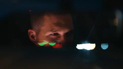 Handsome young man looking into the rear view mirror while driving the car in Stock Footage 249767670