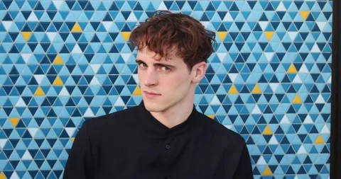 Handsome young man looks with piercing eyes. Will to win. Motivating individual Stock Footage 237412692