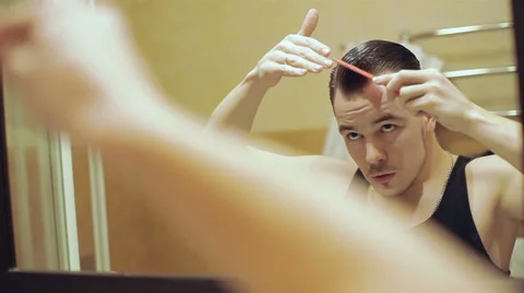 Handsome young man makes himself presentable hairstyle Stock Footage 37018212