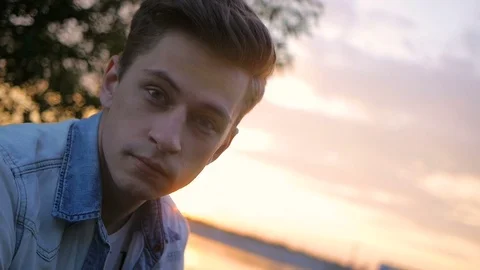 Handsome young man model posing on the lake at sunset Stock Footage 72838853