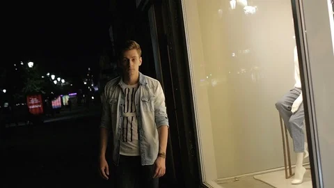 Handsome young man model posing at night in storefront Video stock 72839492