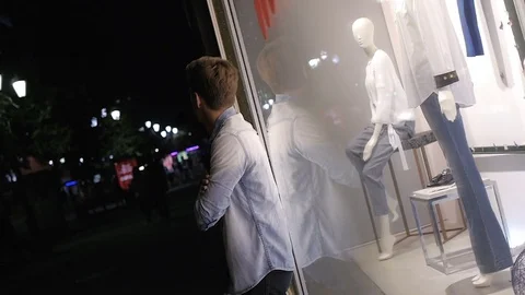 Handsome young man model posing at night in storefront Video stock 72839975