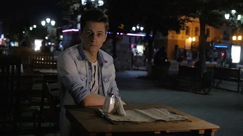 Handsome young man model posing in an outdoor cafe at night Video stock 72840034