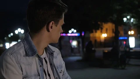 Handsome young man model posing in an outdoor cafe at night Stock-Footage 72840099