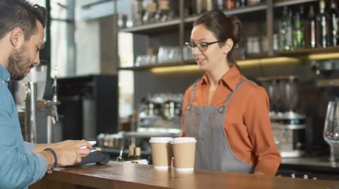 Handsome Young Man Paying for Takeaway Coffee with Mobile Phone at Coffee Shop. Stock Footage