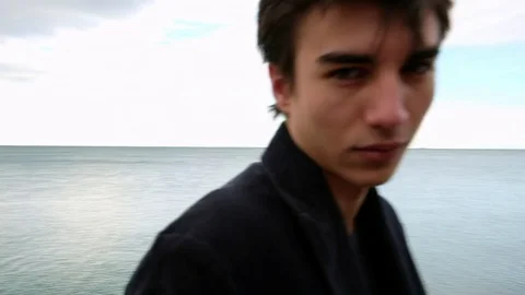 Handsome young man portrait by the sea Stock Footage