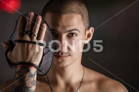 Handsome young man posing with swim paddle indoors Stock Photos