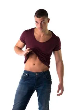 Handsome young man pulling up t-shirt, showing abs Stock Photos